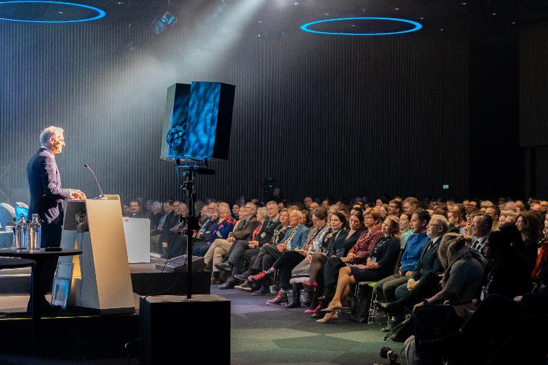 en mann taler for et stort publikum